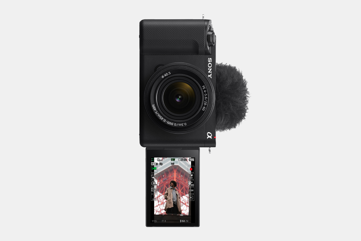 Fotoaparato ZV-E1 vaizdas su į priekį atverstu LCD ekranu, vertikaliame informacijos ekrane rodomas vyras